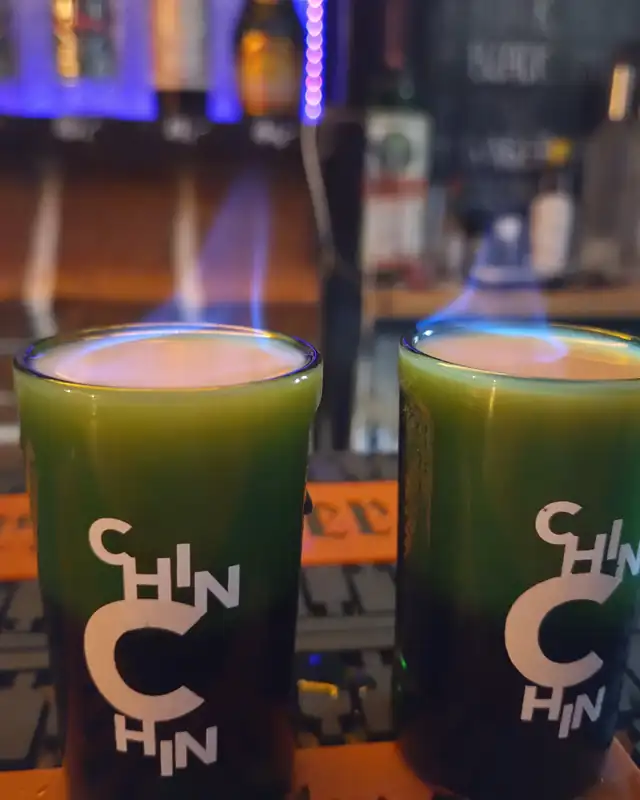 Dwa płonące zielone shoty na barze